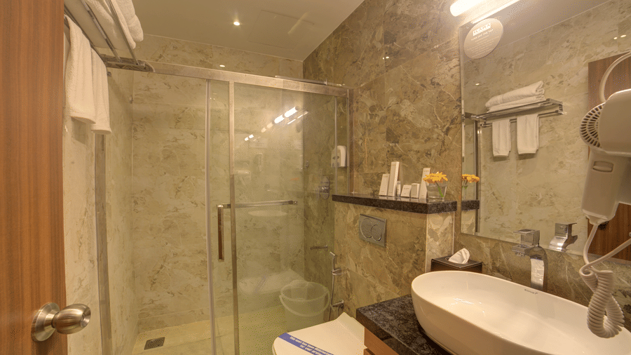 A bathroom fully equipped with essential toiletries besides a wash basin at Ilara Hotels & Spa, Tada.