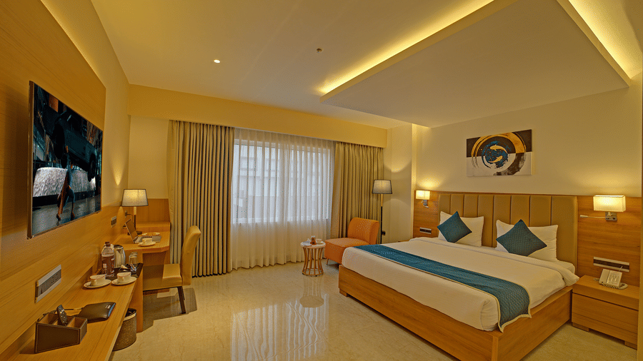 Full-view shot of the Signature Suite with a back lit false ceiling above the above the double bed at Ilara Hotels & Spa, Tada.