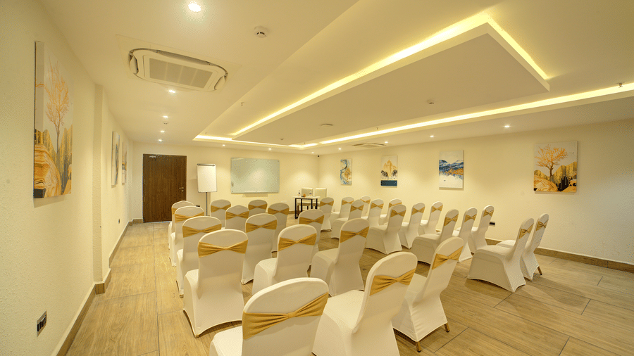 Full-view shot of the banquet hall at Ilara Hotels & Spa, Tada with all the chairs arranged in a classroom setting facing towards the projector screen.