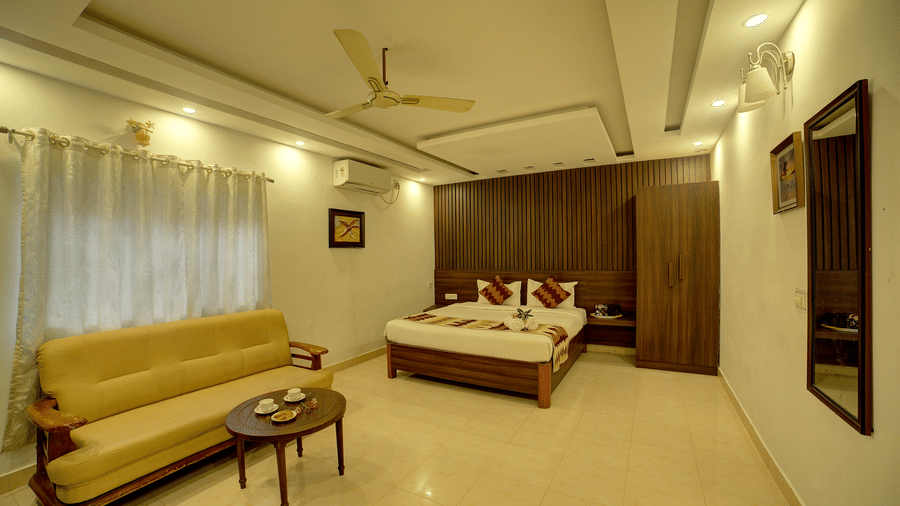 Bright and airy room with sofa seating and a ceiling fan at Kailash Conventions ECR.