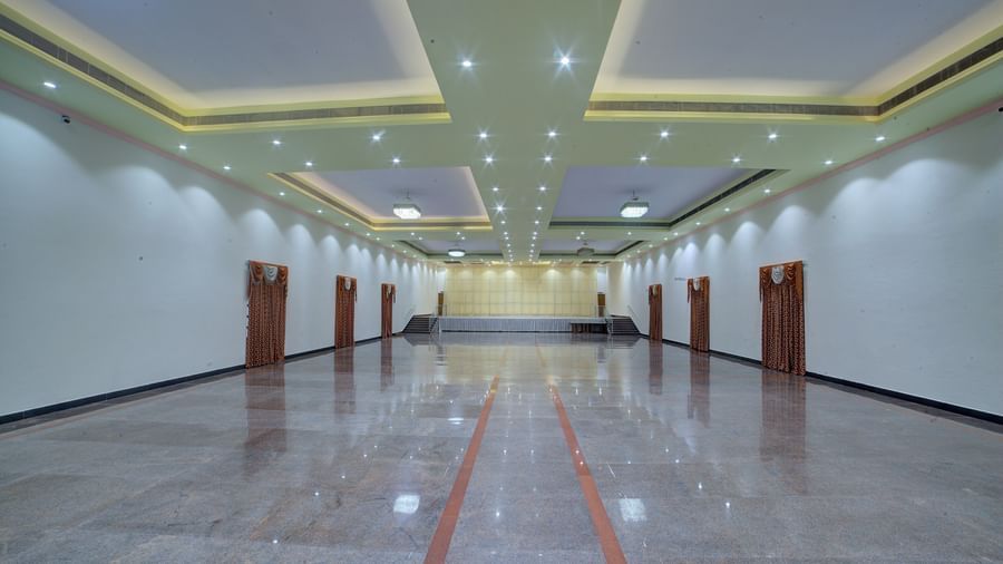 Long, well-lit hall with decorative ceiling panels and polished floors at Kailash Conventions ECR.