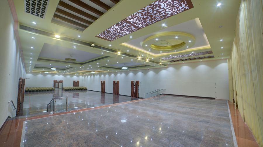 Stylish banquet hall with glossy flooring and ornate ceiling lights at Kailash Conventions ECR.