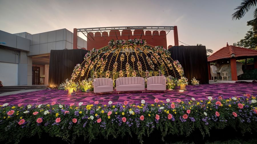 Outdoor stage decorated with vibrant flowers and backdrop for grand celebrations at Kailash Conventions ECR.