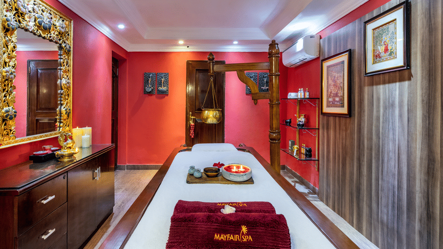 Luxurious spa treatment room with red interiors and massage bed at Mayfair Lagoon
