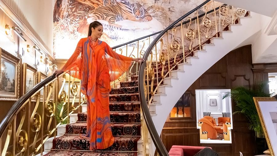 A woman walking down the stairs into the hotel lobby - The Claridges New Delhi