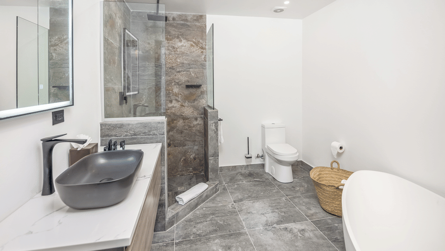 A bathroom featuring a walk-in shower with a glass screen, a toilet, a bathtub and a sink at Tamarind Hills Resort and Villas, Antigua.