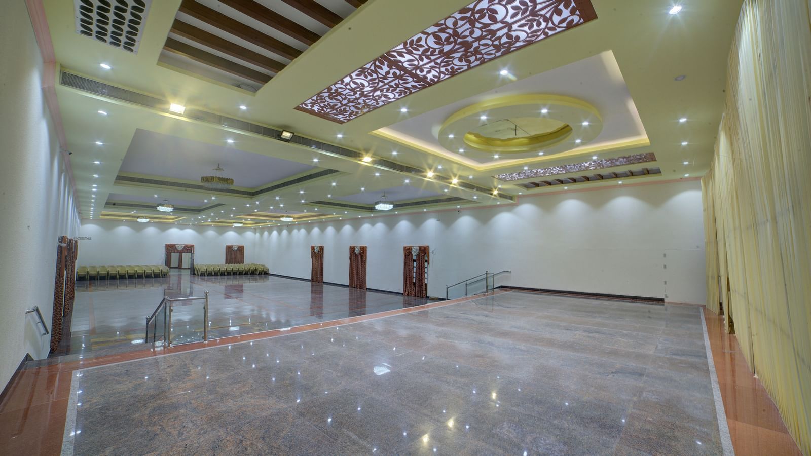 Stylish banquet hall with glossy flooring and ornate ceiling lights at Kailash Conventions ECR.