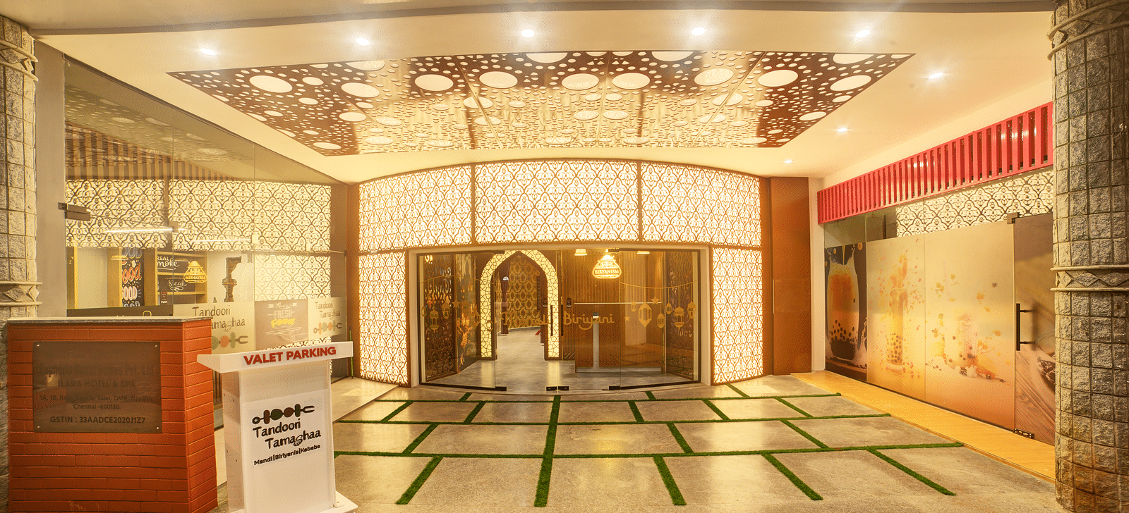 Entrance with a grand traditional decor, wooden counter, and decorative flooring at Ilara Hotels & Spa, OMR, Chennai