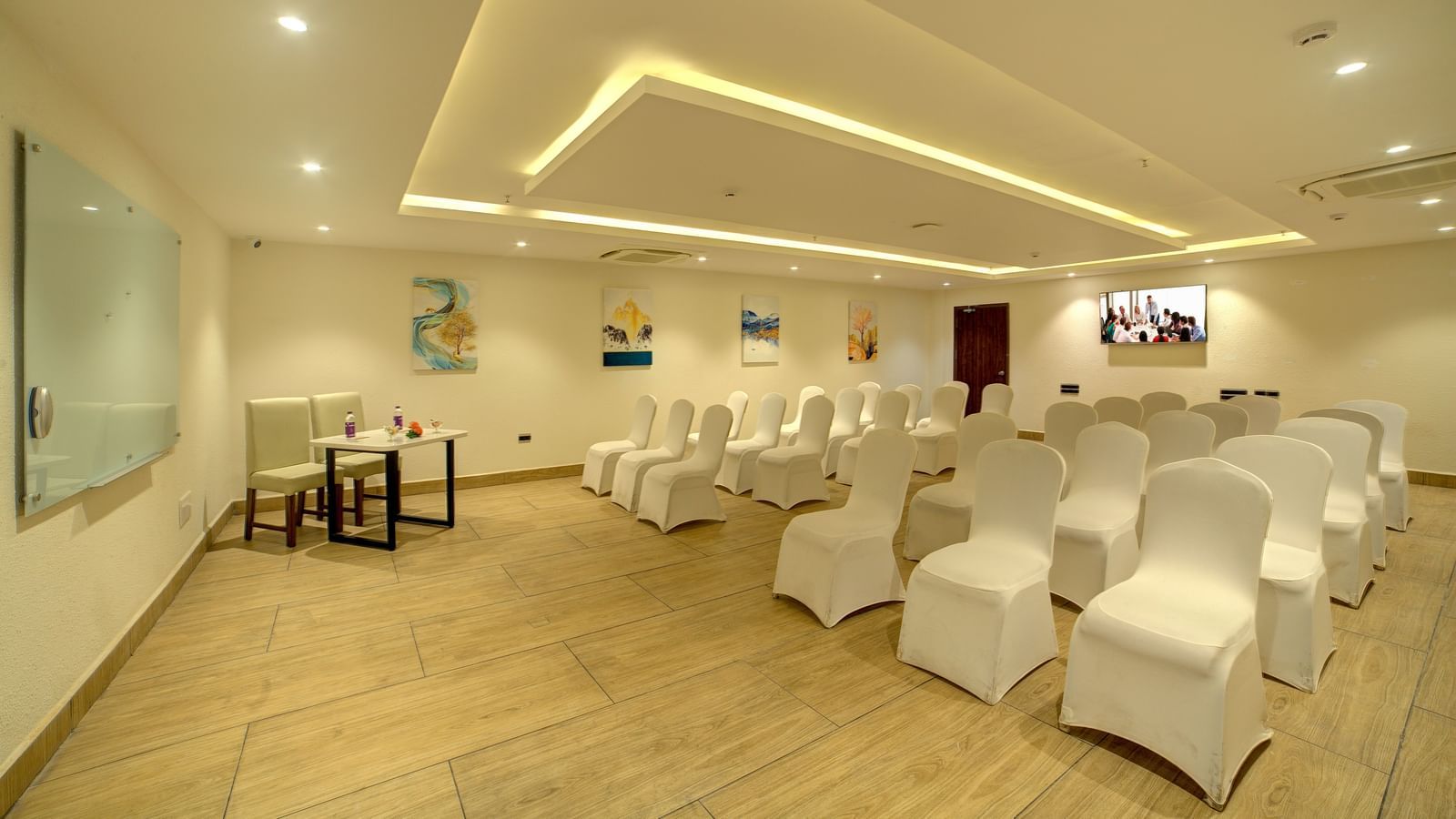 A banquet hall with chairs arranged in three in a row facing towards the projector at Ilara Hotels & Spa, Tada.