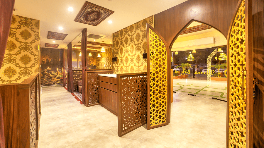 Decorative corridor with arches leading to intimate dining booths at Ilara Hotels & Spa, OMR, Chennai