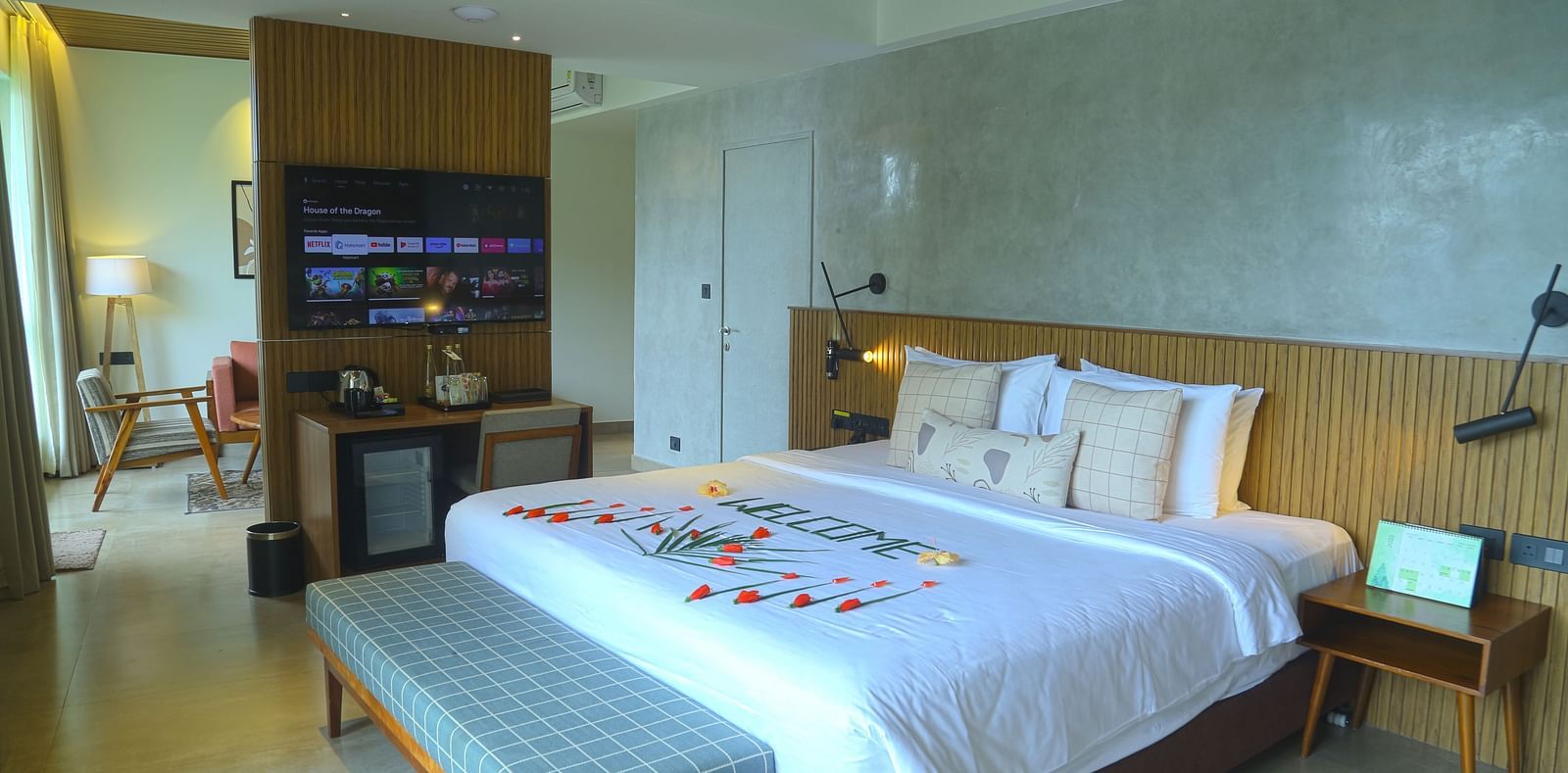 An image of the pent house room with a king size bed, couch, bed side table, and flat screen TV - Great Trails Yercaud by GRT Hotels