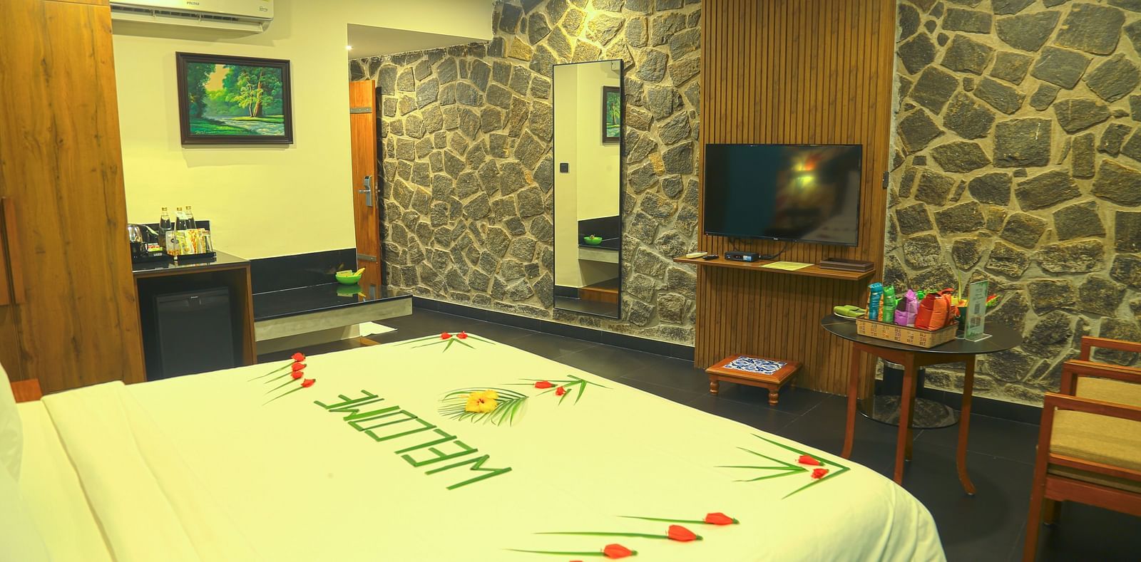 An image of a a valley view room with king size bed, bed side table, flat screen TV, wardrobe, air-conditioner, and decorative items - Great Trails Yercaud by GRT Hotels