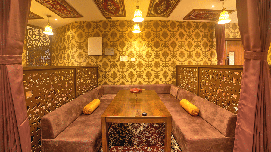 Stylish dining corner with ethnic gold patterns and soft lighting at Ilara Hotels & Spa, OMR, Chennai