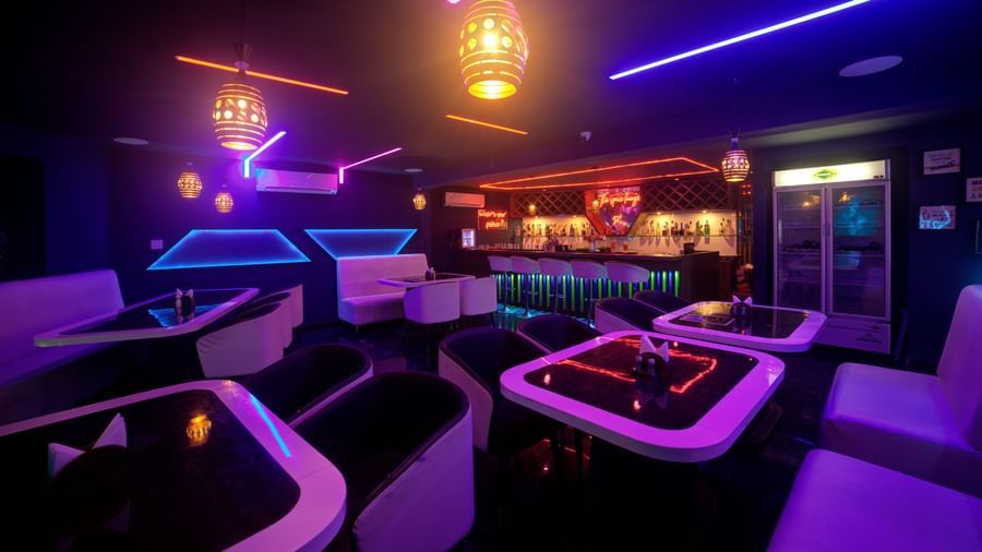 Lounge interior with glowing purple and blue lights and elegant white seating at Ilara Hotels & Spa, OMR, Chennai