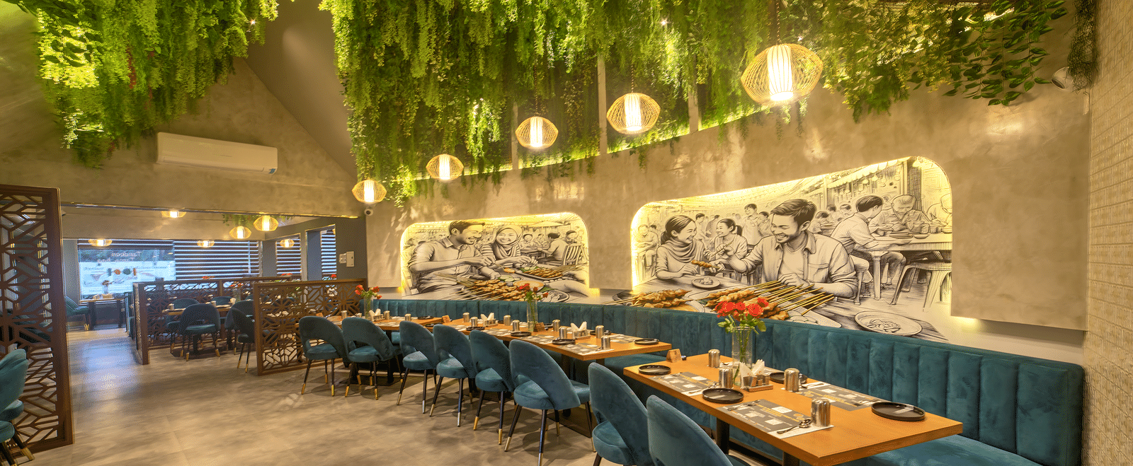 Long dining table under a lush green ceiling canopy at Ilara Hotels & Spa, OMR, Chennai