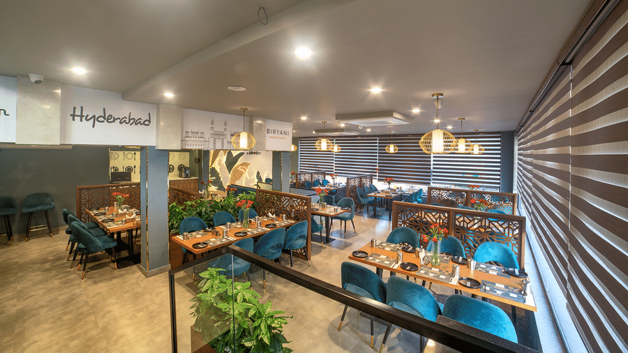 Modern dining area with teal chairs and ambient lighting at Ilara Hotels & Spa, OMR, Chennai