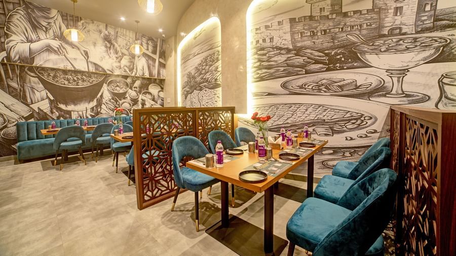 Artistic booth dining with illuminated mural and modern decor at Ilara Hotels & Spa, OMR, Chennai