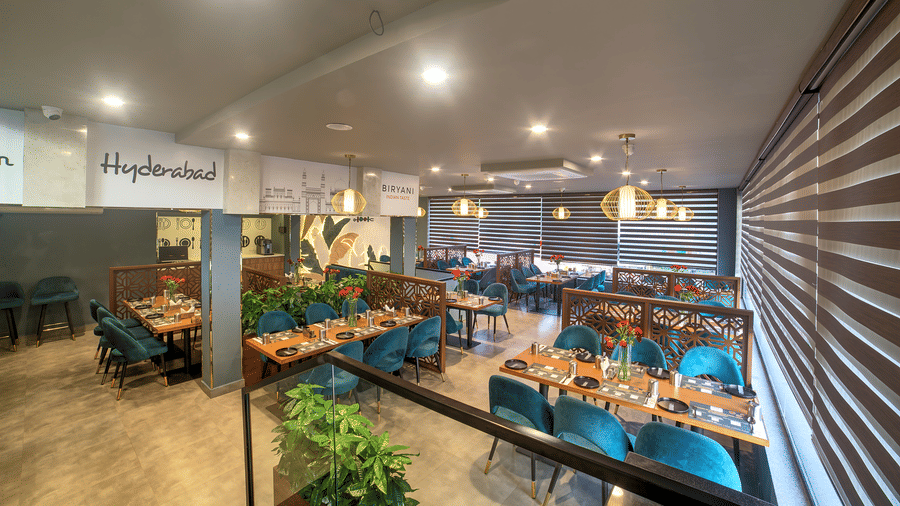 Modern dining area with teal chairs and ambient lighting at Ilara Hotels & Spa, OMR, Chennai