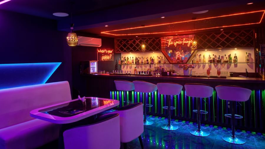 Neon-lit lounge with futuristic booth seating and ambient lighting at Ilara Hotels & Spa, OMR, Chennai