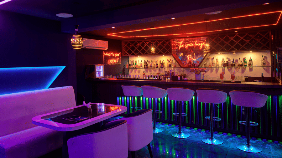 Neon-lit lounge with futuristic booth seating and ambient lighting at Ilara Hotels & Spa, OMR, Chennai