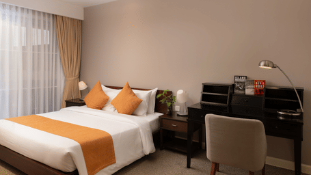 Penthouse bedroom at Central Mansions, Phnom Penh featuring a king bed, dedicated workspace, and floor to ceiling windows.