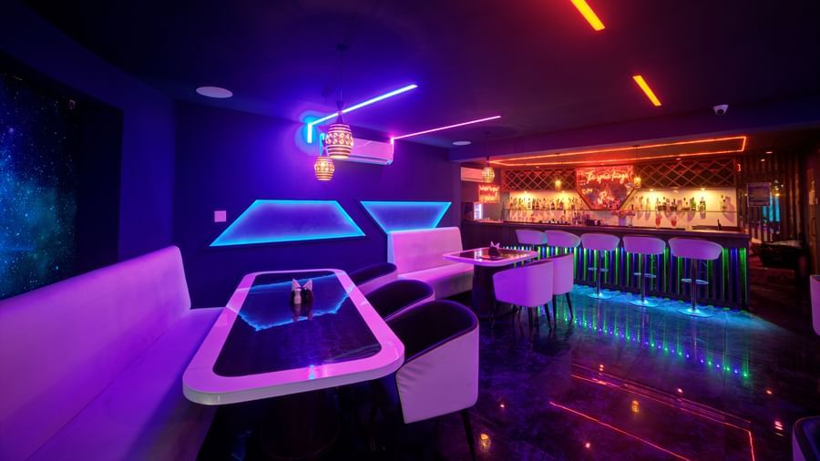 Wide shot of vibrant nightclub with modern decor and sleek bar at Ilara Hotels & Spa, OMR, Chennai