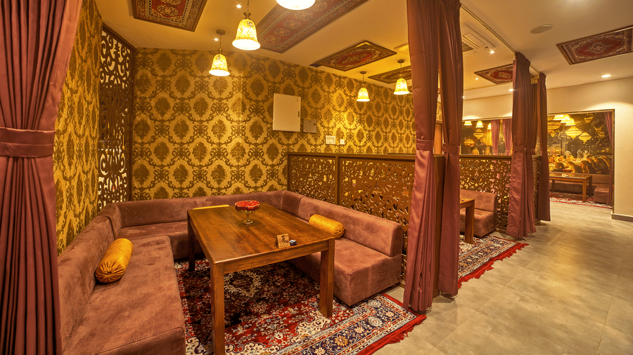 Cosy dining with ornate wooden decor and warm lighting at Ilara Hotels & Spa, OMR, Chennai