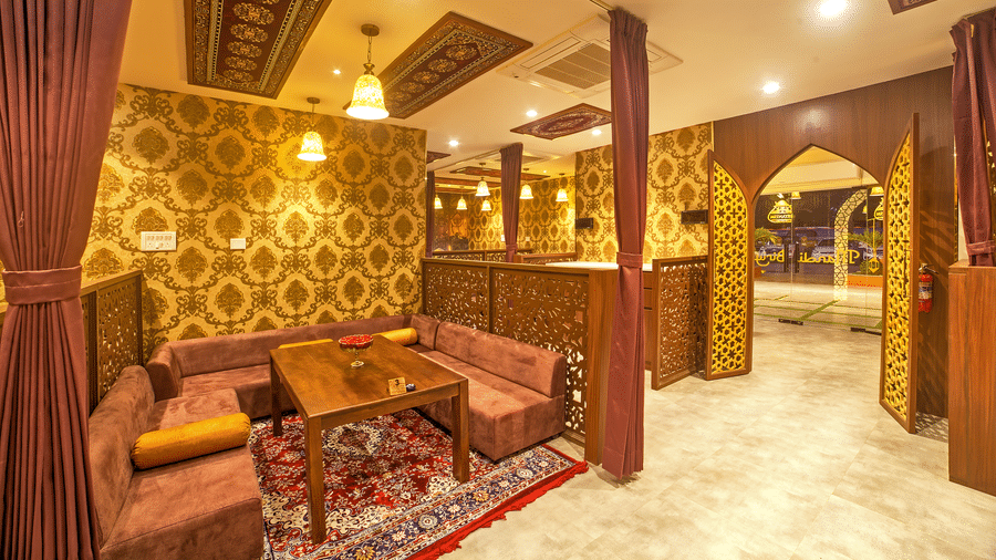 Cosy dining with ornate wooden decor and warm lighting at Ilara Hotels & Spa, OMR, Chennai