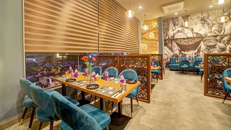 Chic restaurant interiors with wooden accents and floral centrepieces at Ilara Hotels & Spa, OMR, Chennai
