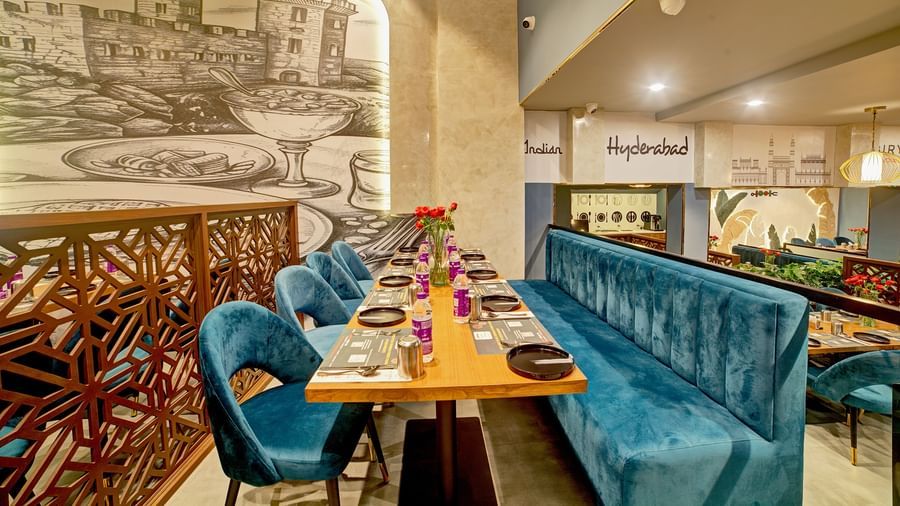 Cosy corner booth with ornate partition and wall illustrations at Ilara Hotels & Spa, OMR, Chennai