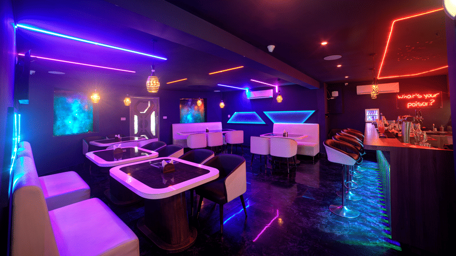 Stylish seating with neon geometric wall lights in lounge bar at Ilara Hotels & Spa, OMR, Chennai