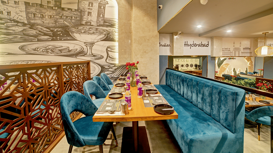 Cosy corner booth with ornate partition and wall illustrations at Ilara Hotels & Spa, OMR, Chennai