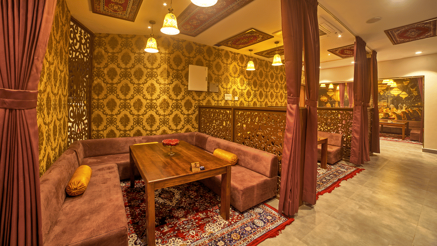 Cosy dining with ornate wooden decor and warm lighting at Ilara Hotels & Spa, OMR, Chennai