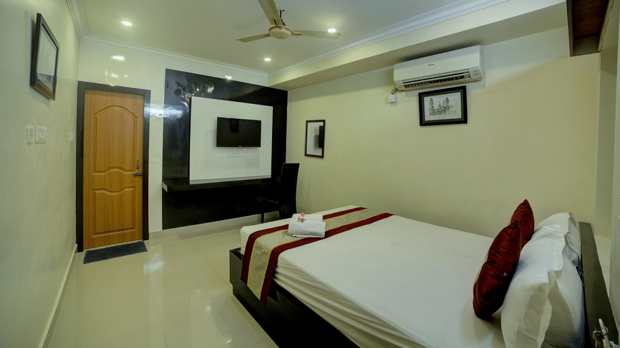 A well-appointed Deluxe Room featuring a comfortable double bed, modern amenities, and warm interior lighting - Kailash Conventions ECR
