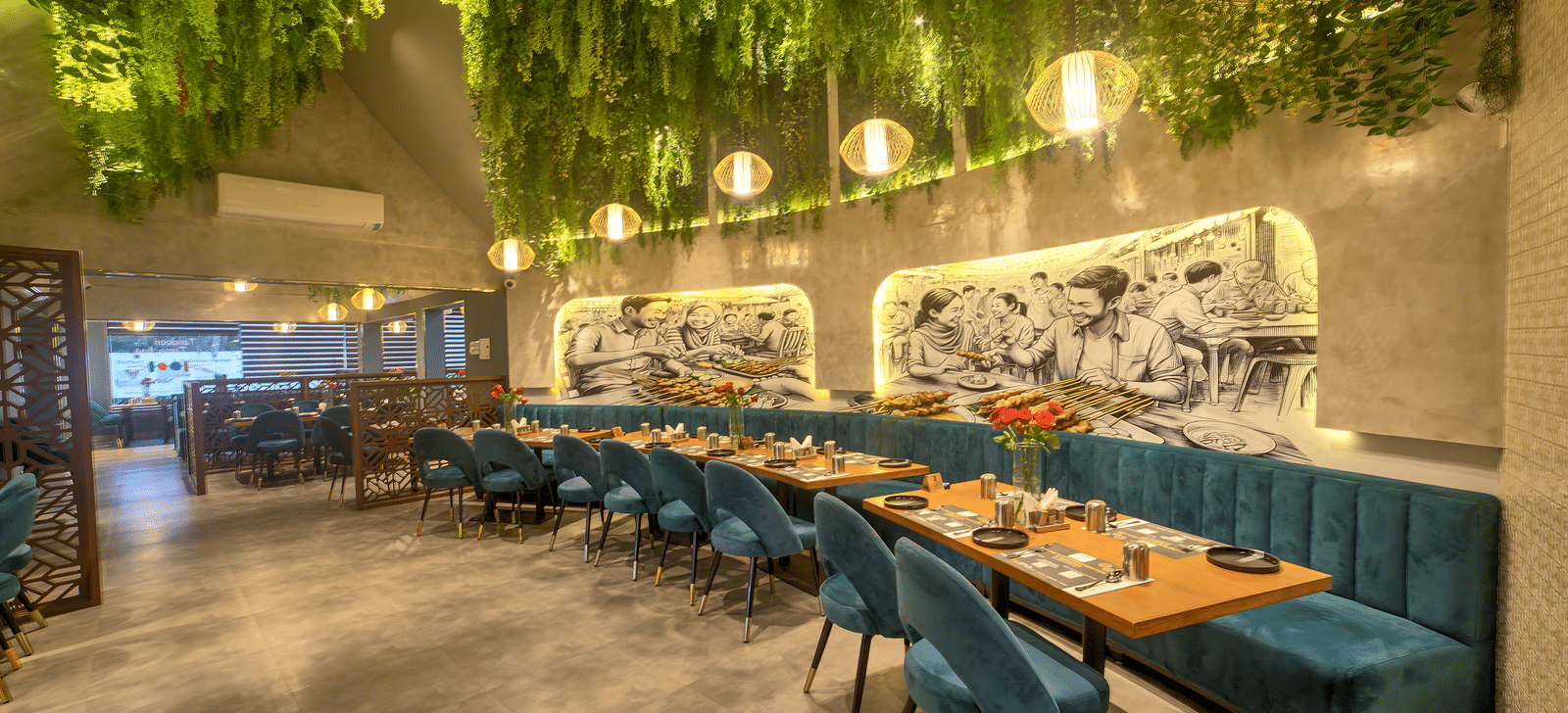 Long dining table under a lush green ceiling canopy at Ilara Hotels & Spa, OMR, Chennai