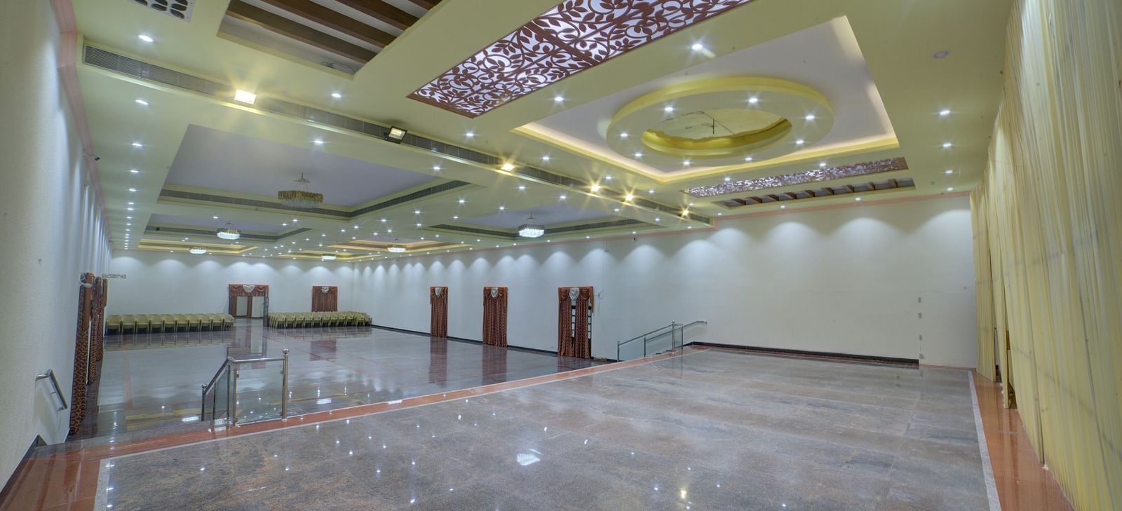 Stylish banquet hall with glossy flooring and ornate ceiling lights at Kailash Conventions ECR.