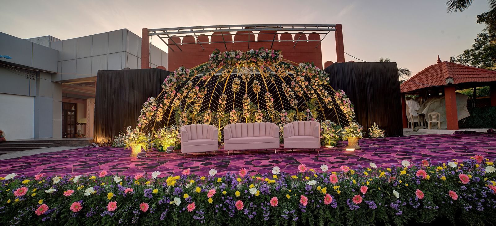 Outdoor stage decorated with vibrant flowers and backdrop for grand celebrations at Kailash Conventions ECR.