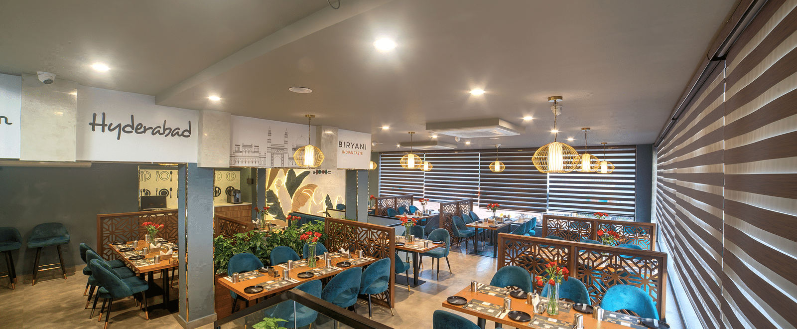 Modern dining area with teal chairs and ambient lighting at Ilara Hotels & Spa, OMR, Chennai