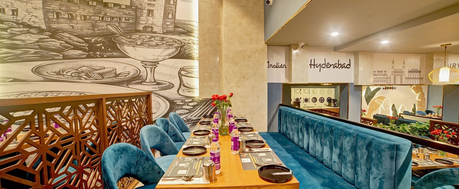 Cosy corner booth with ornate partition and wall illustrations at Ilara Hotels & Spa, OMR, Chennai