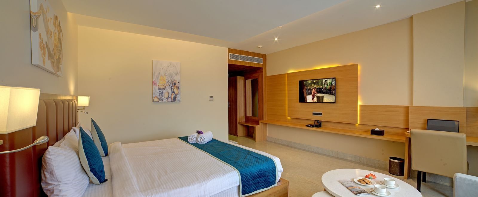 Corner view shot of the Junior Suite featuring a coffee table kept besides the double bed at Ilara Hotels & Spa, Tada.