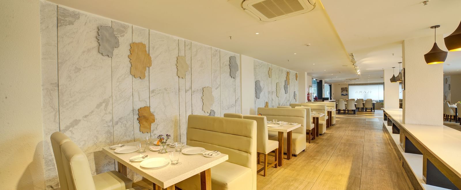 A wide angle shot of the dining area at Ilara Hotels & Spa, Tada with cushioned couches around the dining tables at Moti Mahal.
