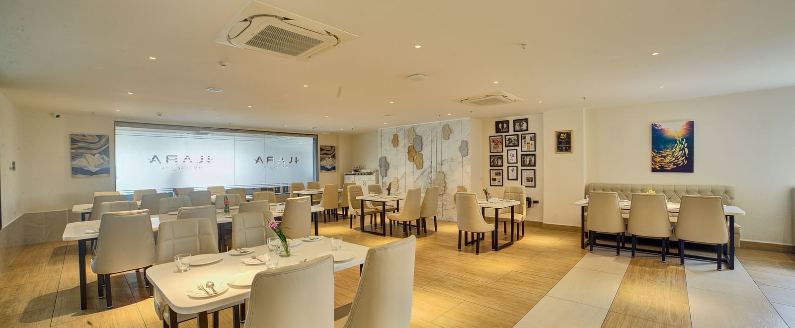 Back view of the Moti Mahal Restaurant with neatly arranged chairs and dining tables at Ilara Hotels & Spa, Tada.