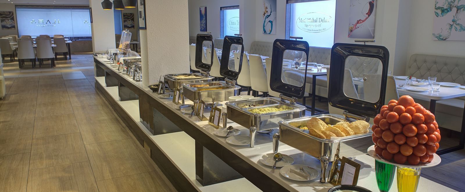 A close up shot of buffet counter with chafing dishes and serving spoons in front of it at Ilara Hotels & Spa, Tada.
