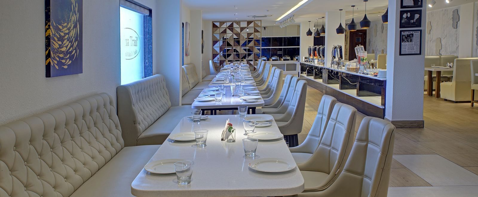 Side angle view of the dining tables with plates kept on it at Moti Mahal restaurant at Ilara Hotels & Spa, Tada.