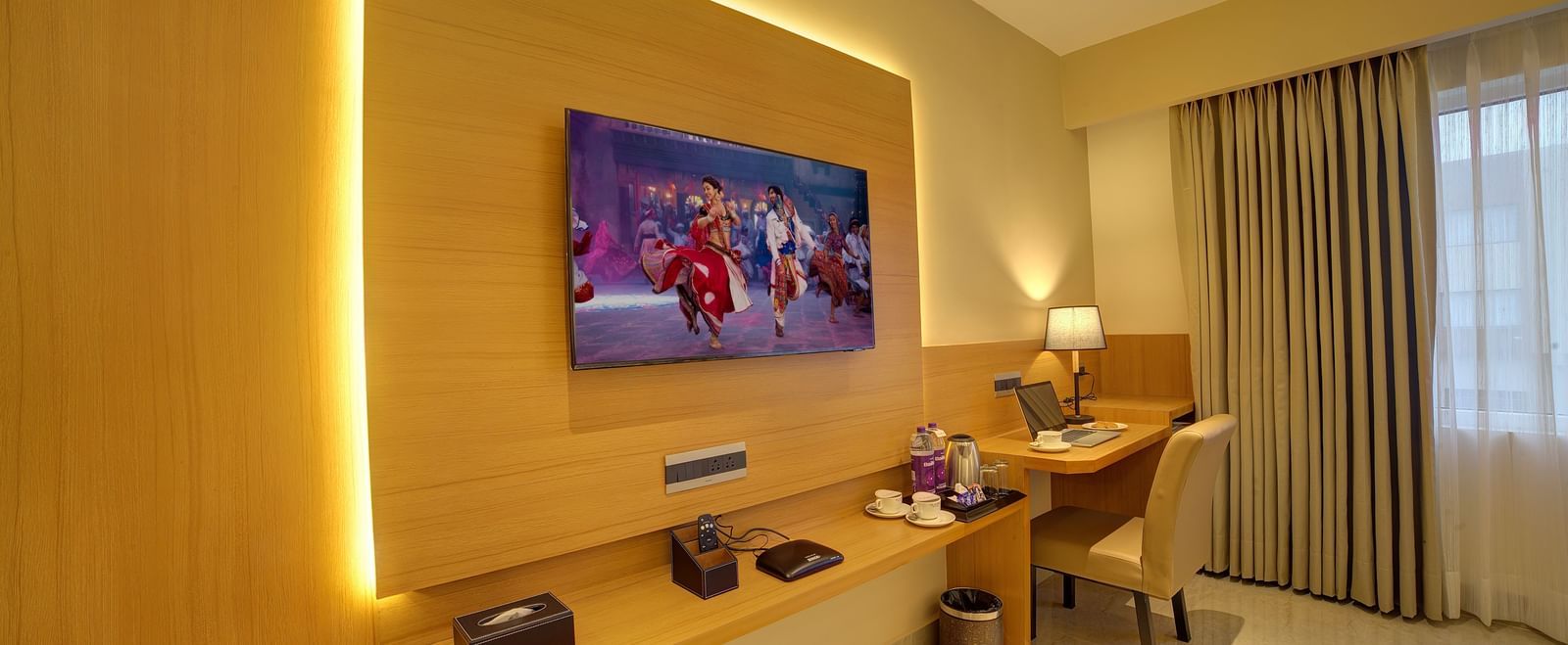 Corner view shot of the TV table with a wall mounted flat screen television and a work station in the corner of the Signature Suite at Ilara Hotels & Spa, Tada.