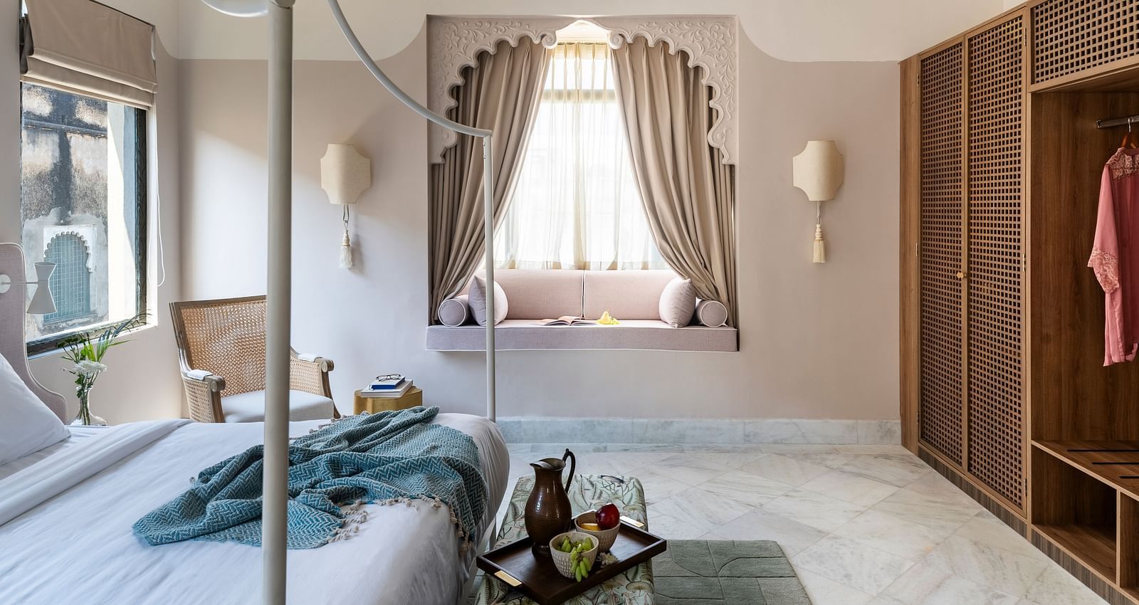 a double bed with a small seating area at the base of the bed inside one of the rooms - Manuscript - Jhilwara Haveli, Udaipur