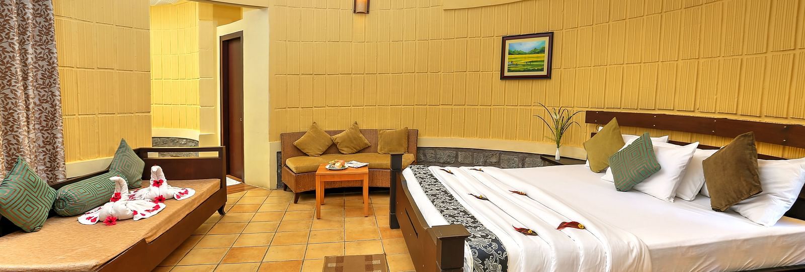 a bedroom with a large bed opposite a sofa cum bed and another sofa on the side - Kadkani River Resort, Coorg