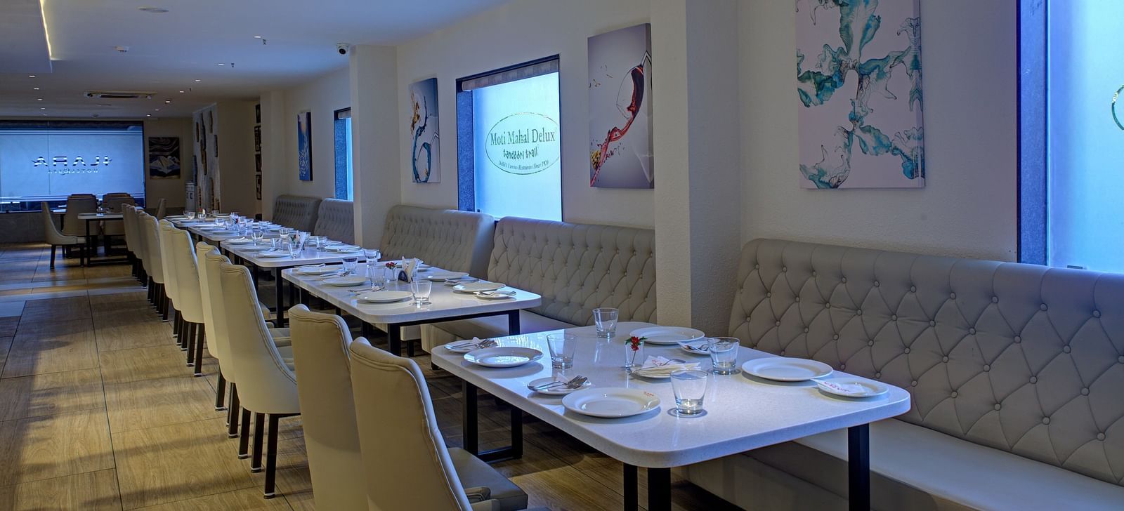 Corner view shot of the Moti Mahal Restaurant with dim lighting falling on the dining tables from the translucent glass windows at Ilara Hotels & Spa, Tada.
