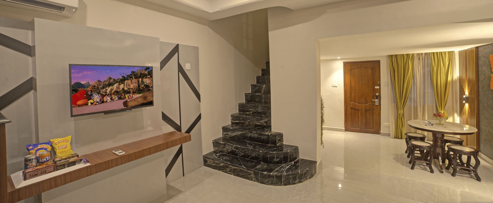An area with television and spiral staircasat at Ilara Hotels & Spa, OMR, Chennai