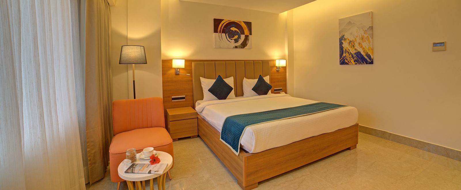 Corner view shot of the Signature Suite featuring a double bed with a cyan bed runner over it at Ilara Hotels & Spa, Tada.